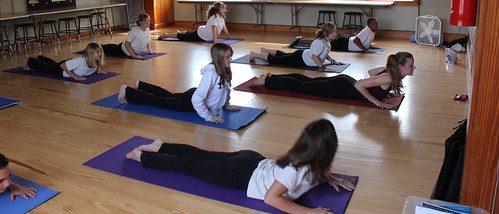 Class members lifting into a gentle backbend on mats